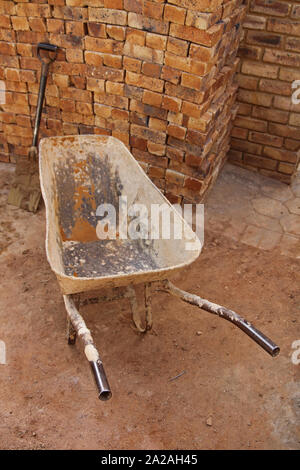 Ruota barrow e pala accanto a una pila di mattoni, Moreleta Park; Pretoria, provincia di Gauteng, Sud Africa. Foto Stock