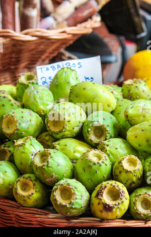 Verde di frutti di Opuntia su un mercato locale a Funchal, Madeira, Portogallo. Ficodindia o di fichi d'India. Frutti Esotici sono cresciute su cactus. Traduzione del segno: Tabaibos - Frutti di Opuntia in portoghese. Foto Stock