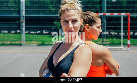 Sportivi in posa con bracci incrociati Foto Stock