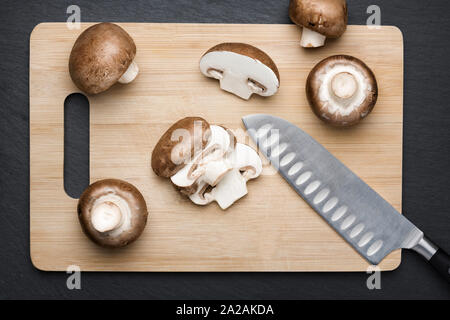 Alcuni funghi tagliati a fettine sul bordo di taglio. Foto Stock