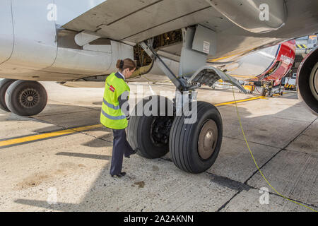 Pilota pre facendo controlli di volo e a piedi intorno a Foto Stock