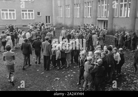 Gli studenti di una scuola di Berlino Est romp sul parco giochi durante la pausa. Foto Stock
