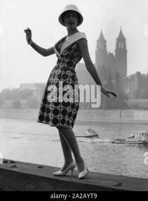 Modello Evelyn in posa sulle sponde del fiume Elba a un abbigliamento casual. Indossa un abito modellato con il bianco scarpe, guanti e cappello, progettato dal designer di moda Heinz Bormann da Magdeburg. Foto Stock