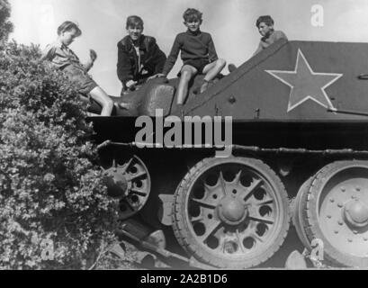 I bambini salire di un carro armato sovietico, che è stato istituito presso la Heldendenkmal der Roten Armee (eroi' monumento dell'Armata rossa) su Schwarzenbergplatz a Vienna. Foto Stock