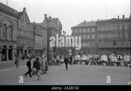 Vista sulla piazza del mercato di Schwerin e il circostante facciate. In primo piano i pedoni, in background parcheggiate automobili e motocicli può essere visto. Foto Stock