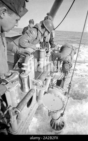 La Lindau classe minehunter costiere durante un esercizio del 6. Minensuchgeschwader (sesta miniera squadrone di spazzamento) nel Mare del Nord. I soldati al lavoro sul minesweeping ingranaggio del prato fiorito. Qui, i soldati tirando fuori un sonobuoy per ripulire il mare miniere con un detonatore acustica. Foto Stock