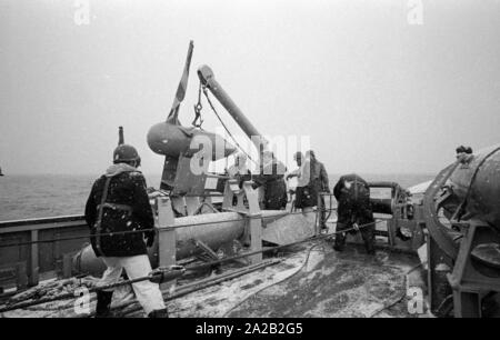 La Lindau classe minehunter costiere durante un esercizio del 6. Minensuchgeschwader (sesta miniera squadrone di spazzamento) nel Mare del Nord. I soldati al lavoro sul minesweeping ingranaggio del prato fiorito. Foto Stock