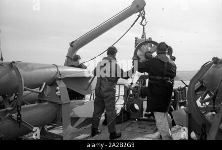 La Lindau classe minehunter costiere durante un esercizio del sesto Minesweeper squadrone nel Mare del Nord. I soldati al lavoro sul minesweeping ingranaggio del prato fiorito. Foto Stock