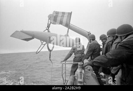 La Lindau classe minehunter costiere durante un esercizio del 6° Squadrone minesweeping nel Mare del Nord. I soldati al lavoro sul dragamine ingranaggio. Qui essi sono tirando fuori un galleggiante del dispositivo di compensazione. Foto Stock