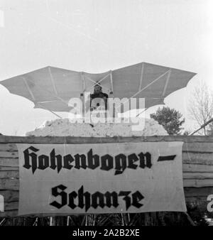 La foto mostra l'hobby-tinkerer Hans Frank con la sua costruzione che appare come un 'flying sledge'. Apparentemente ha voluto provare la sua costruzione al Hohenbogen ski jump vicino Neukirchen. Il salto con gli sci è stato costruito nel 1952, ma a partire da 1959 nessun Concorsi regolari sono stati detenuti lì e il salto con gli sci è stata demolita negli anni sessanta. Foto Stock