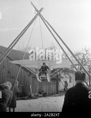 La foto mostra l'hobby-tinkerer Hans Frank con la sua costruzione che appare come un 'flying sledge'. Apparentemente ha voluto provare la sua costruzione al Hohenbogen ski jump vicino Neukirchen. Il salto con gli sci è stato costruito nel 1952, ma a partire da 1959 nessun Concorsi regolari sono stati detenuti lì e il salto con gli sci è stata demolita negli anni sessanta. Foto Stock