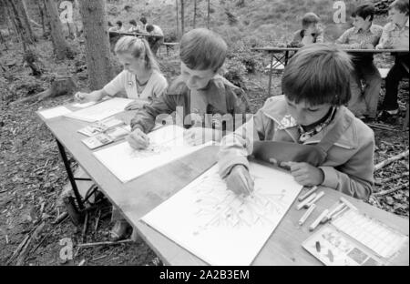 Una giornata del bosco è stato organizzato per i bambini disabili con una escursione nella foresta bavarese in prossimità di Kelheim. La foto mostra il gruppo di bambini su un sentiero di bosco. Essi siedono a tabelle di birra e dipingere quadri. Foto Stock