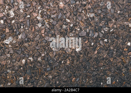 Tessitura grossolana di pietre, ghiaia. Strada superficie grunge. Pietra marrone dello sfondo. Piccoli ciottoli sul pavimento, naturale parete di roccia. Foto Stock