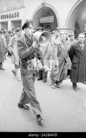 A Monaco di Baviera diverse proteste sono state detenute nel 1953/54 contro i nuovi orari di apertura prolungati (e quindi le ore di lavoro) di negozi di sabato. Il talvolta violenti scontri erano a quel tempo denominata "Ladenschlusskrieg' (orario di chiusura guerra), come la polizia municipale utilizzato un alto livello di violenza. Foto di un funzionario di polizia che danno le istruzioni su un megafono. Foto Stock