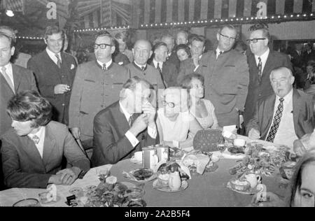 In occasione dell'Oktoberfest in 1970 Willy Brandt è stato ospite nel tendone della Fischer-Vroni. La foto mostra lui in conversazione con ulteriori ospiti seduti intorno a lui. Foto Stock