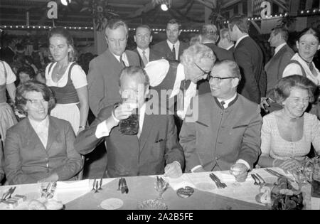 In occasione dell'Oktoberfest in 1970 Willy Brandt è stato ospite nel tendone della Fischer-Vroni. La foto mostra a lui con un boccale di birra, ulteriormente gli ospiti sono seduti intorno a lui. Foto Stock