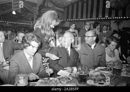 In occasione dell'Oktoberfest in 1970 Willy Brandt è stato ospite nel tendone della Fischer-Vroni. La foto mostra una giovane donna di ottenere un autografo da Brandt. Foto Stock