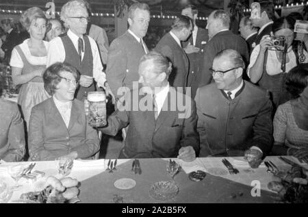 In occasione dell'Oktoberfest in 1970 Willy Brandt è stato ospite nel tendone della Fischer-Vroni. La foto mostra a lui con un boccale di birra, ulteriormente gli ospiti sono seduti intorno a lui. Foto Stock