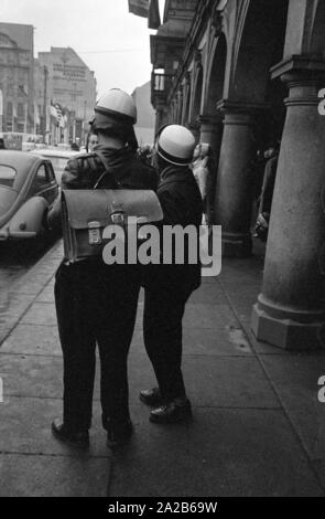 La città durante la Fiera di primavera 1960. Due uomini con caschi motociclistici. Foto Stock