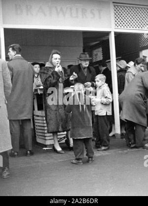 La città durante la Fiera di primavera 1960. Le persone a una salsiccia stallo. Foto Stock