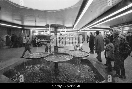 Fontana al piano mezzanino a Stachus, che comprende un centro commerciale con negozi come il negozio di abbigliamento "Pelzpavillon" (a destra). Foto Stock