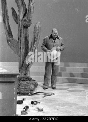 Il impersonator di Hoss da Bonanza, Dan Blocker, nel corso di una apparizione nel programma televisivo di 3x9. In primo piano è un mucchio di bottiglie e alla sua sinistra, un cactus di grandi dimensioni. Foto Stock