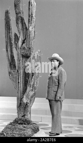 Il impersonator di Hoss da Bonanza, Dan Blocker, accanto a un grande cactus sul 3x9 TV show. Foto Stock