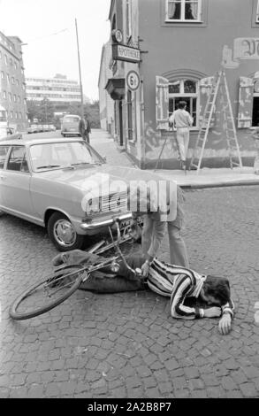 Un incidente - auto contro il ciclista - è una simulazione per esercizio di un volontario del servizio di salvataggio. Foto Stock