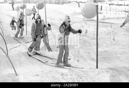Bambini a un corso di sci della Skischule Garmisch. La società marker" annuncia la sua sicurezza attacchi da sci con striscioni. Foto Stock