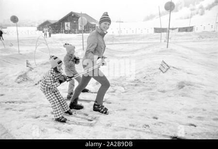 Bambini a un corso di sci della Skischule Garmisch. La società marker" annuncia la sua sicurezza attacchi da sci con striscioni. Foto Stock