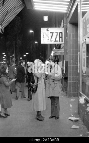 Un giovane condivide un pezzo di pizza. Foto Stock