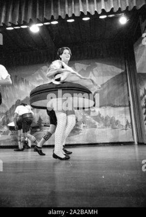 Un ballerino in costume tradizionale con battenti mantello durante una performance dei bavaresi tradizionali danze folk in una città termale in Baviera. Foto Stock