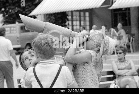 I bambini cercano di guardare attraverso il binocolo in un bavarese resort per la salute. Foto Stock