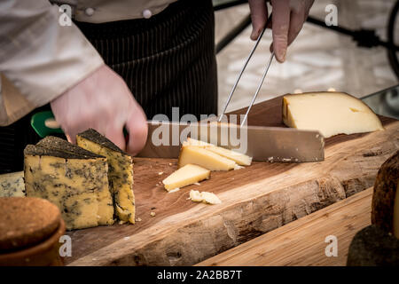 Lo chef del Ristorante il taglio di formaggio sulla tavola di legno, Buffet di Nozze Foto Stock