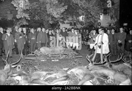 Schloss Fuschl in Hof bei Salzburg a caccia di festival ha avuto luogo nel 1971. La lussuosa residenza di caccia dal XV secolo è un luogo di incontro per gli ospiti selezionati da tutto il mondo. Nella foto: Il proprietario degli alberghi e master di hunt Carl Adolf Vogel (quarta da sinistra) e sua moglie, l'attrice tedesca Winnie Markus (sesto da sinistra) stand in fila anteriore mentre il sacerdote consacra la cava. Foto Stock