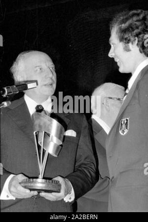 Il Presidente federale Walter Scheel (sinistra) e il calciatore Franz Beckenbauer (r). al banchetto dell'Hilton Hotel di Monaco di Baviera. Scheel presenta Beckenbauer l equità Cup a nome del team. Foto Stock