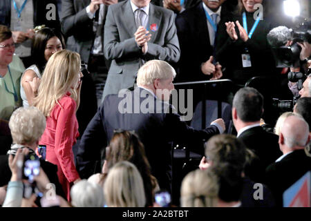 Il primo ministro Boris Johnson lascia con il suo partner Carrie Symonds, dopo aver consegnato il suo intervento durante il congresso del partito conservatore al Manchester Convention Center. Foto Stock