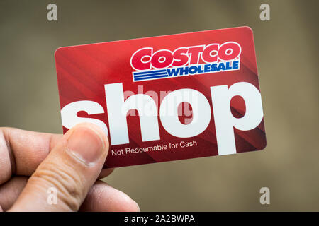 Mano che tiene un Costco wholesale gift card Foto Stock