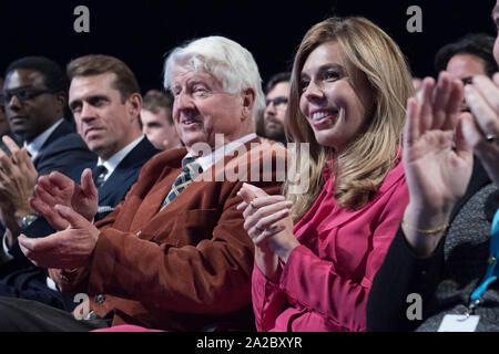 Carrie Symonds e Stanley Johnson, il partner e padre del Primo Ministro Boris Johnson, guardare lui consegnare il suo intervento durante il congresso del partito conservatore al Manchester Convention Center. Foto Stock