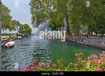 Riva del Garda - la barca in porto con le Alpi di sfondo. Foto Stock