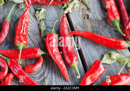 Materie red hot chili peppers su uno sfondo di legno. Vista dall'alto. Foto Stock