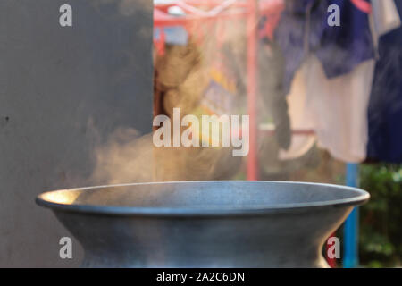 Argento tradizionale sistema di cottura a vapore pentola con emissione di fumo bianco durante la cottura Foto Stock