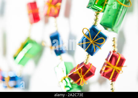 Luminose decorazioni di Natale di avvolgere pacchi contro isolato su bianco Foto Stock