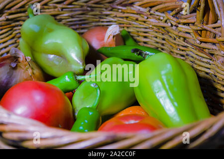 Fresche verdure organiche nel cesto di vimini. Peperone, pomodoro, peperoncino, la cipolla, la carota. Foto Stock