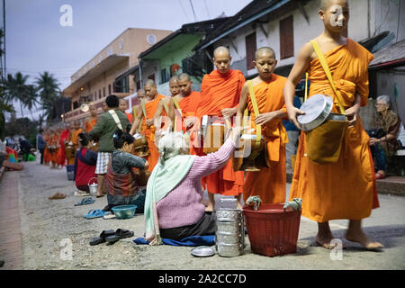 Tak Bat monaci chiamata al ALMS a Alba, Luang Prabang, Luang Prabang provincia nord del Laos Il Laos, sud-est asiatico Foto Stock
