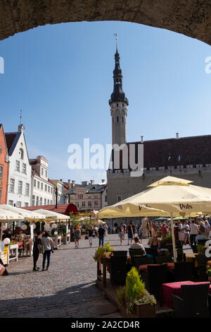 Guardando attraverso arco verso il mercato dell'artigianato sulla piazza del Municipio nella città vecchia di Tallinn, Estonia Foto Stock