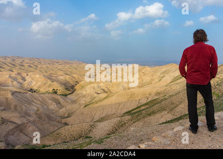 Un uomo sta cercando nel deserto della Giudea, Israele Foto Stock