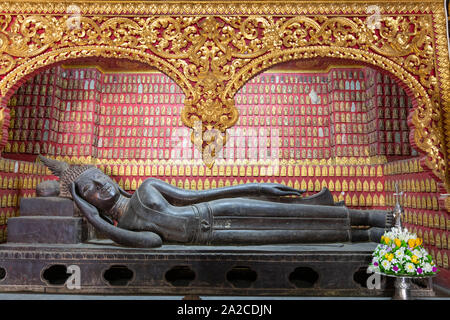 Buddha reclinato all'interno del Hor Pha Daj Sai nyaat (Cappella rossa) al Wat Xieng Thong tempio buddista, Luang Prabang, Luang Prabang provincia, settentrionale Foto Stock