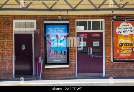 Tutti noi abbiamo il nostro controllo delle impostazioni di privacy su Facebook, cartelloni sulla piattaforma stazione a Brockenhurst, Hampshire, Regno Unito il giorno di sole in settembre Foto Stock