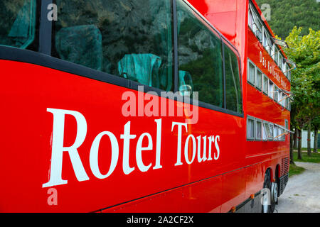 Rosso enorme Mercedes bus, Rotel Tours, nelle Dolomiti italiane, Canazei, Italia Foto Stock